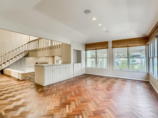 A stylish luxury living room with expansive windows and staircase