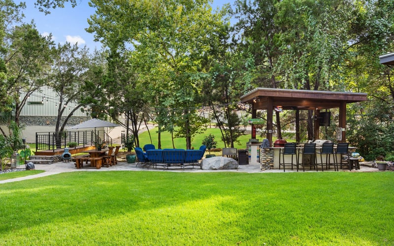 Backyard oasis with outdoor patio furniture, a barbecue grill, and verdant greens