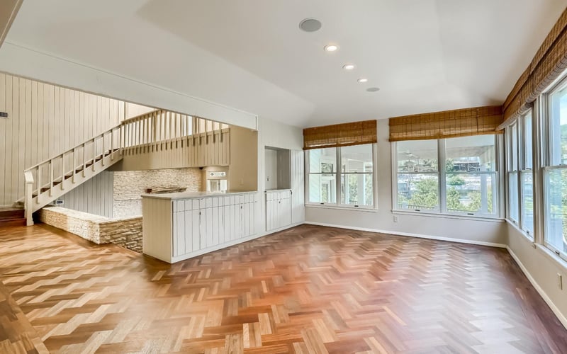 A stylish luxury living room with expansive windows and staircase