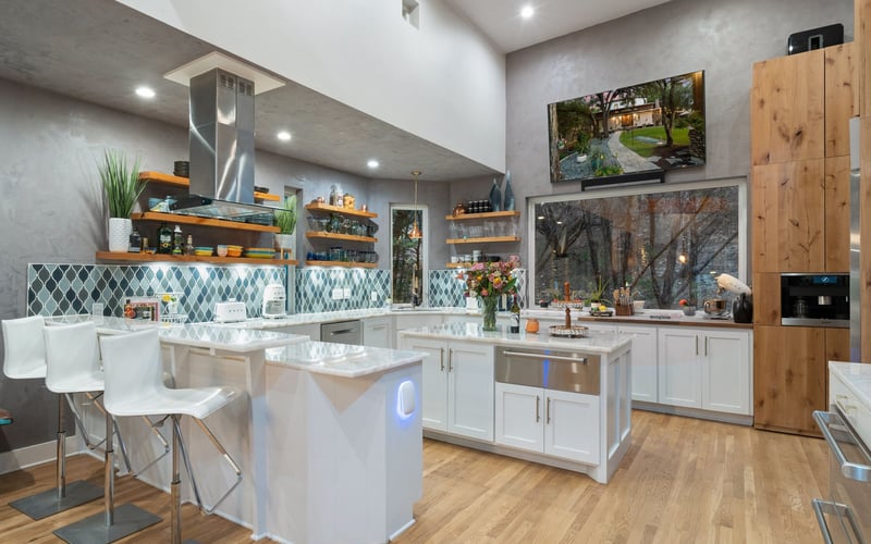 Clean and luxurious kitchen featuring white cabinetry and stainless steel appliances.